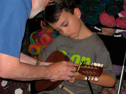 Bouzouki instructor teaching a child how to play the instrument properly.