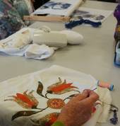 An embroiderer stitching a Baltimore Quilt block